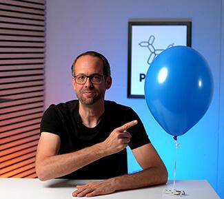 Stefan von Ballonversand zeigt auf einen Pastell-Ballon