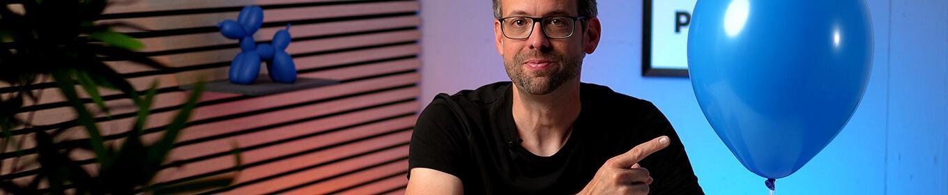 Stefan von Ballonversand zeigt auf einen Pastell-Ballon