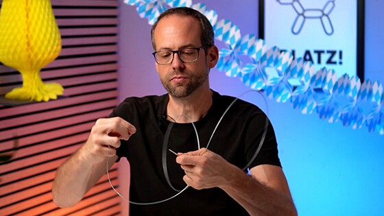 Stefan von bonacker ballonversand öffnet vorsichtig den Draht für die Girlande.