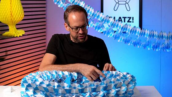 Stefan von bonacker ballonversand verklebt die Girlande an den entsprechenden Stellen, damit sie hält.