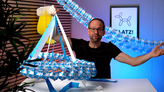 Stefan von bonacker ballonversand hält die Girlande am Band, an welchem sie aufgehängt werden kann.