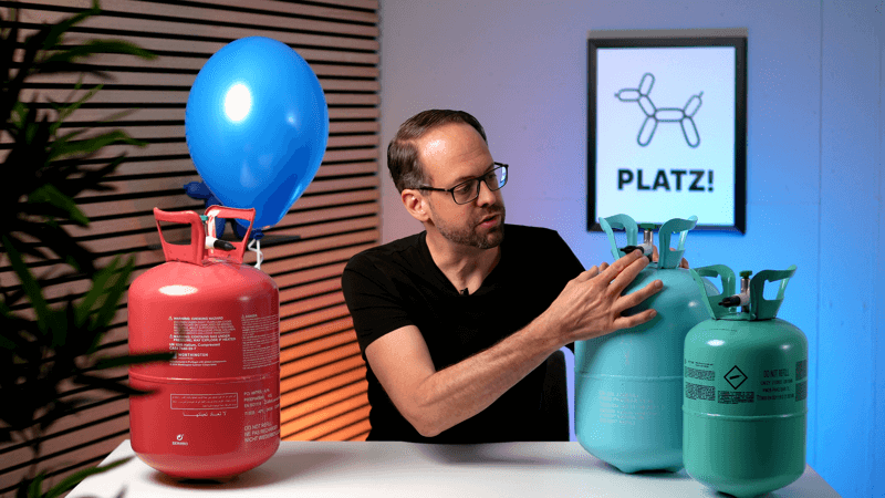 Hand, die das Kipp-Ventil einer Heliumflasche bedient