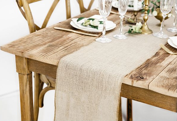 Gedeckter Holztisch mit Jute Tischläufer, Gläsern